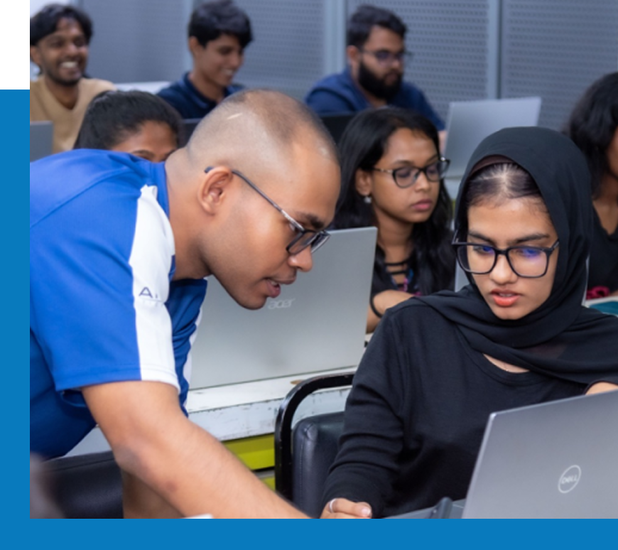 Instructor providing hands-on guidance to students during a computer course in Sri Lanka